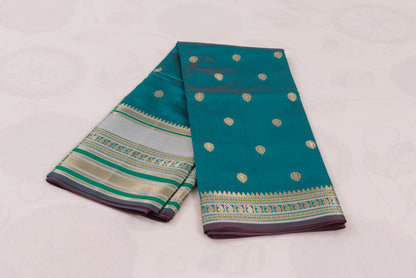 Teal blue Banarasi Semi Katan saree with delicate gold zari butis, stylish check pallu, and matching blouse material